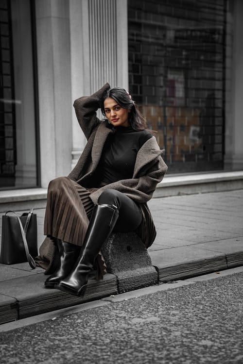 Fashionable Woman Sitting on a Sidewalk 