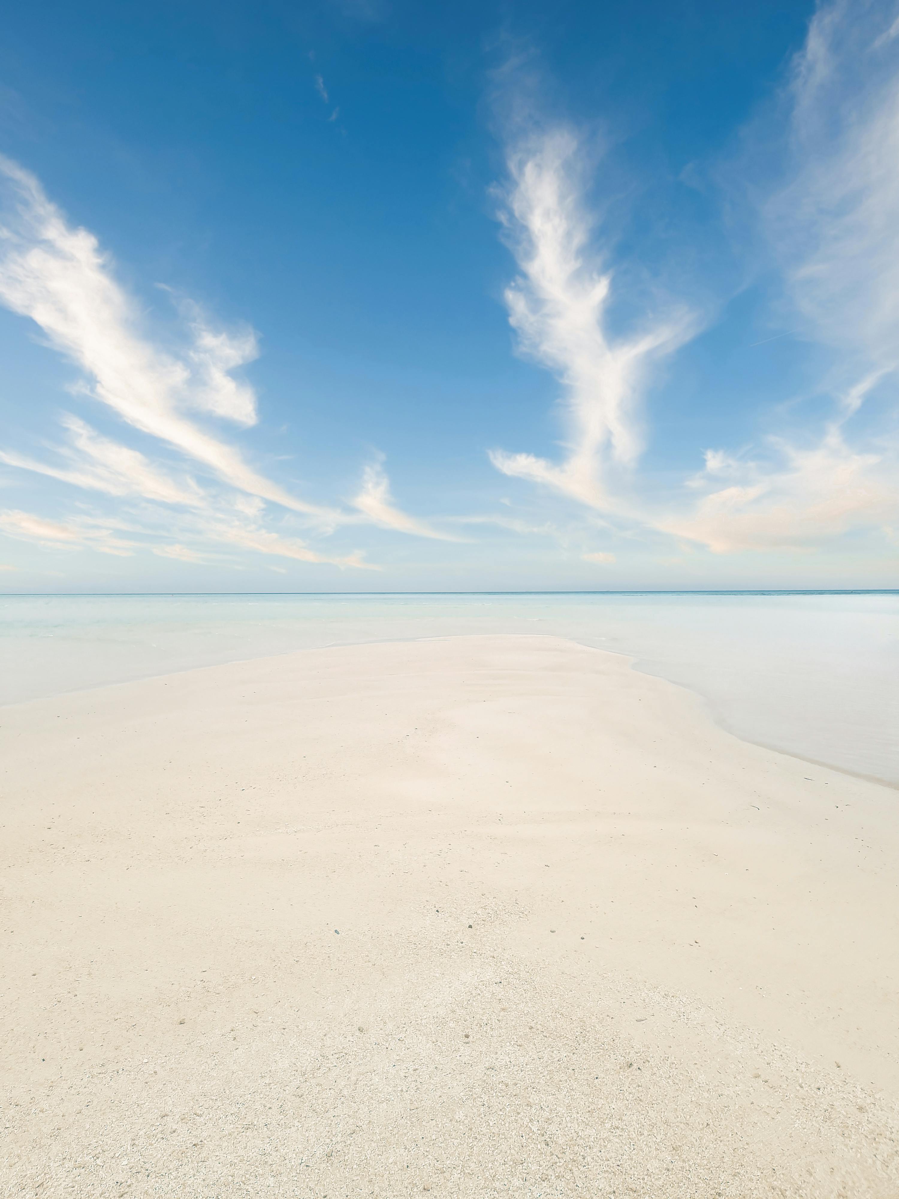 Serene view of Fulhadhoo beach in the Maldives with white sand and clear blue skies, ideal for tropical getaways.