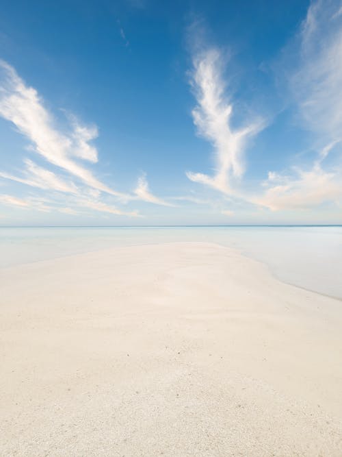 Foto profissional grátis de água azul claro, areia, céu azul