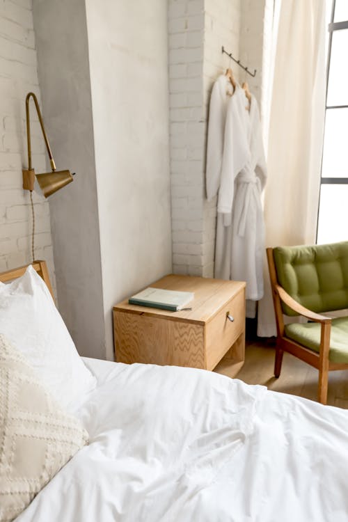 A bed with white sheets and pillows in a room