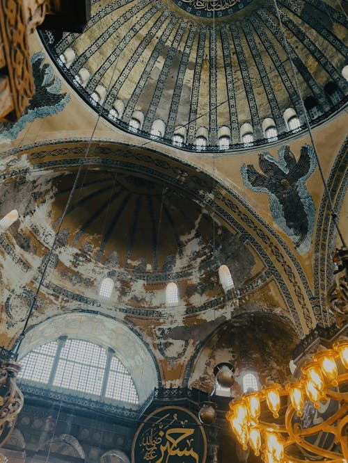 The inside of a building with a dome and chandelier