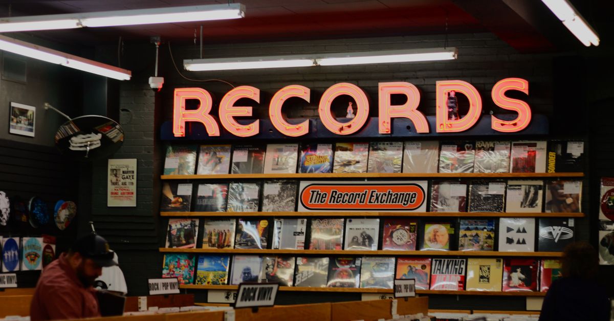 Crowded record store with young people flipping through vinyl bins
