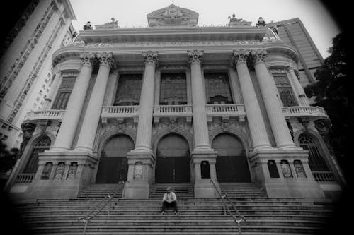 A Man Sitting Alone on the Steps of the Municipal Theater of Rio de Janeiro in Brazil 