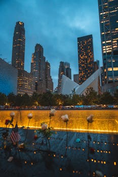 A moody skyline view of the 9/11 Memorial in New York City during dusk.