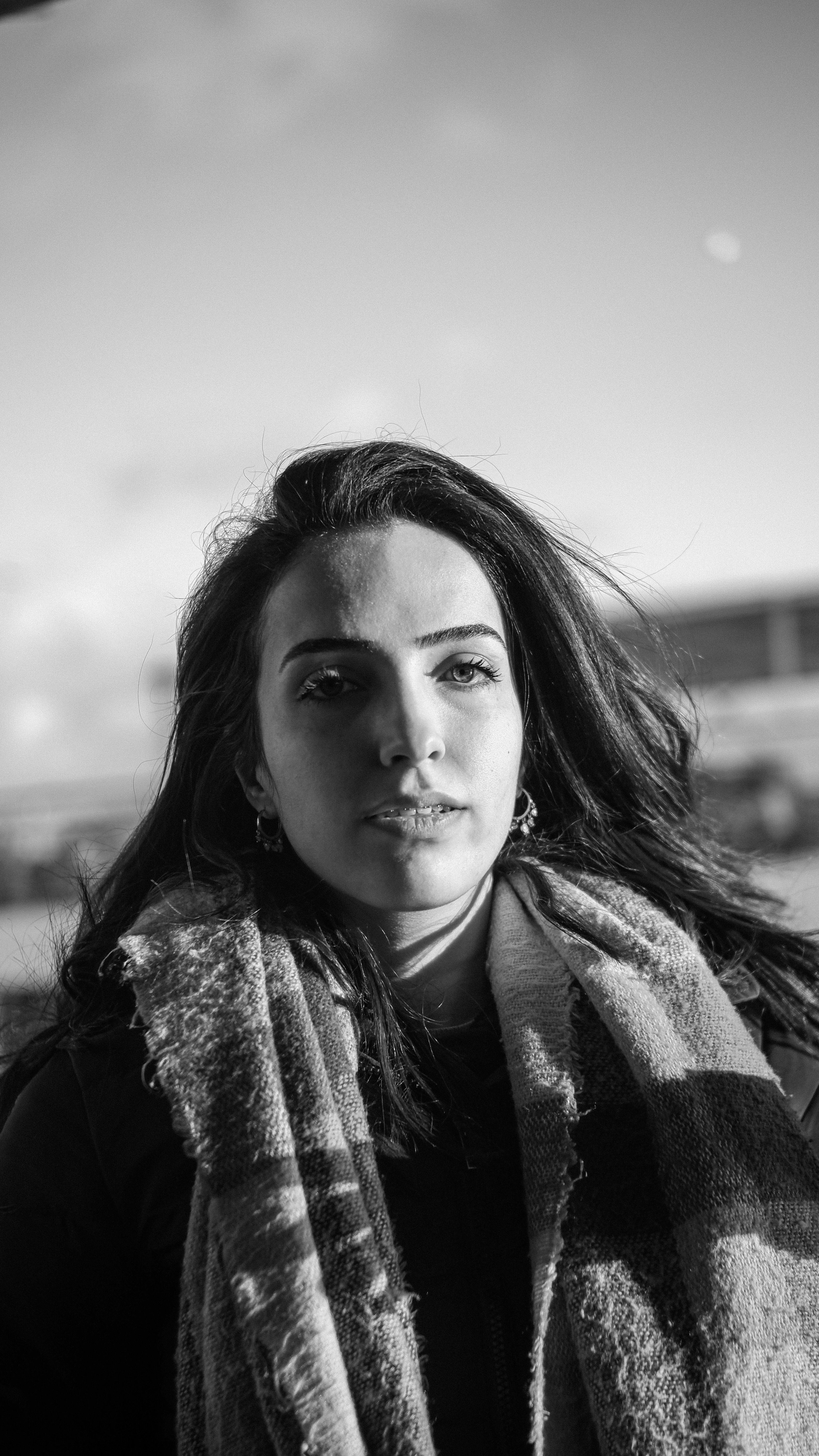 Black and white portrait of a woman wearing a scarf, exuding elegance and mystery.