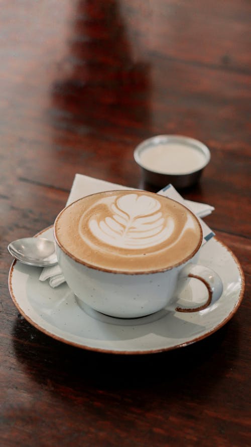 A Cup of Cappuccino with Latte Art Standing on a Table 
