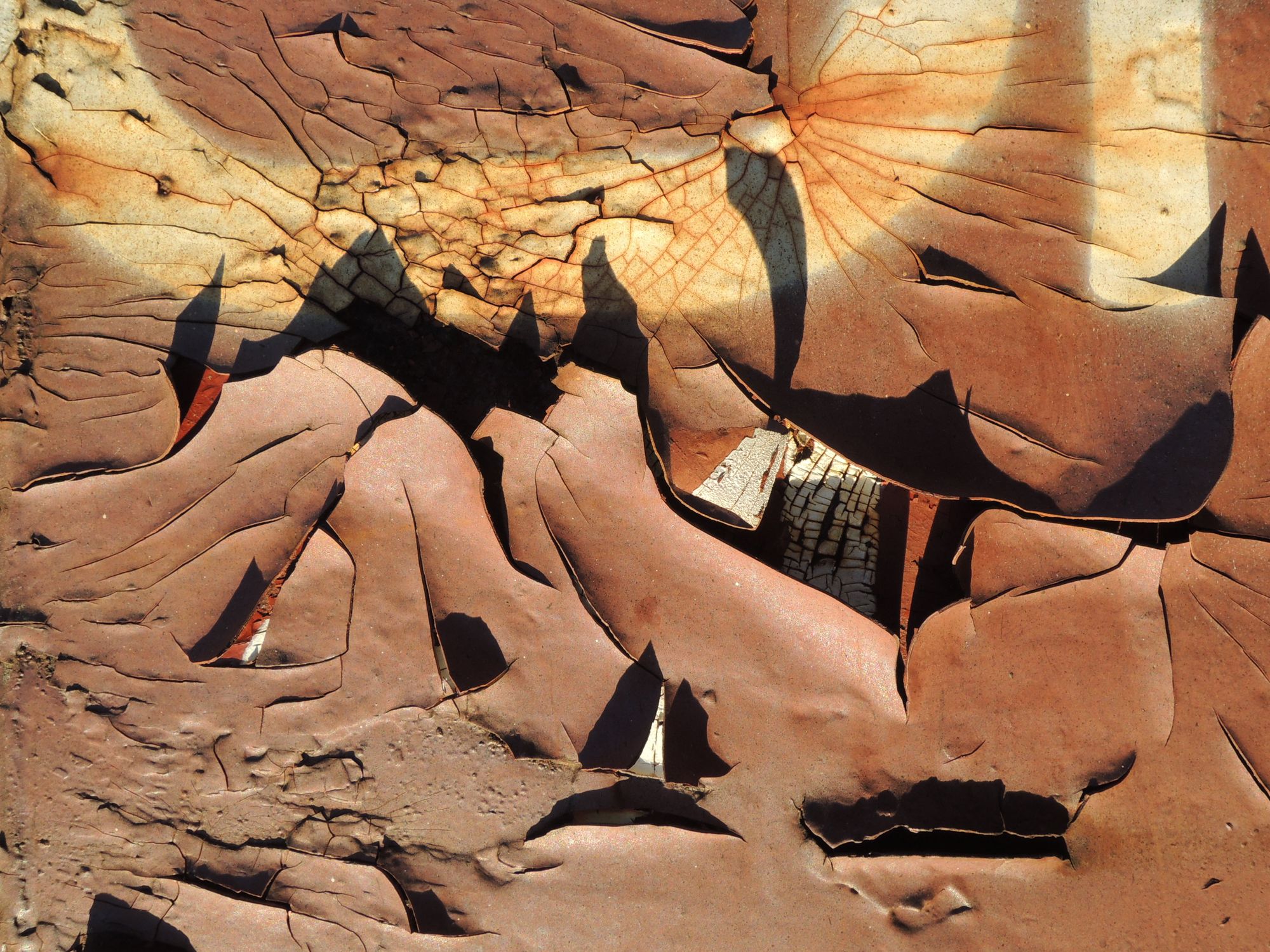 Close-up of eroded and cracked surface creating an abstract desert landscape texture.