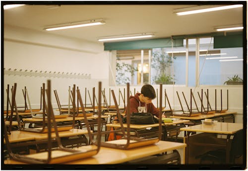 A Boy Sitting alone in a Classroom 