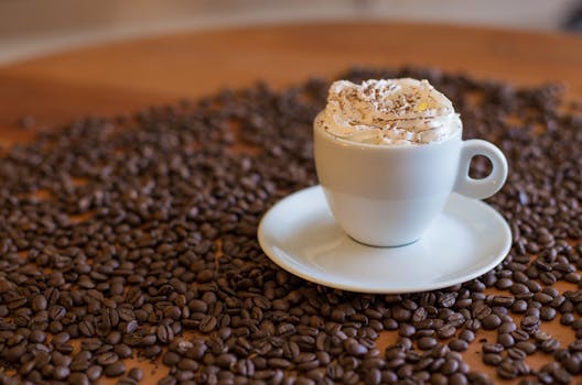 Delight in a creamy coffee topped with whipped cream, nestled among roasted coffee beans.