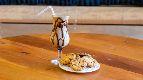 A Milkshake and Cookies Standing on a Table 