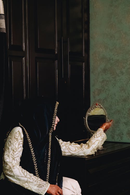 Woman Sitting in Traditional Clothing and with Mirror
