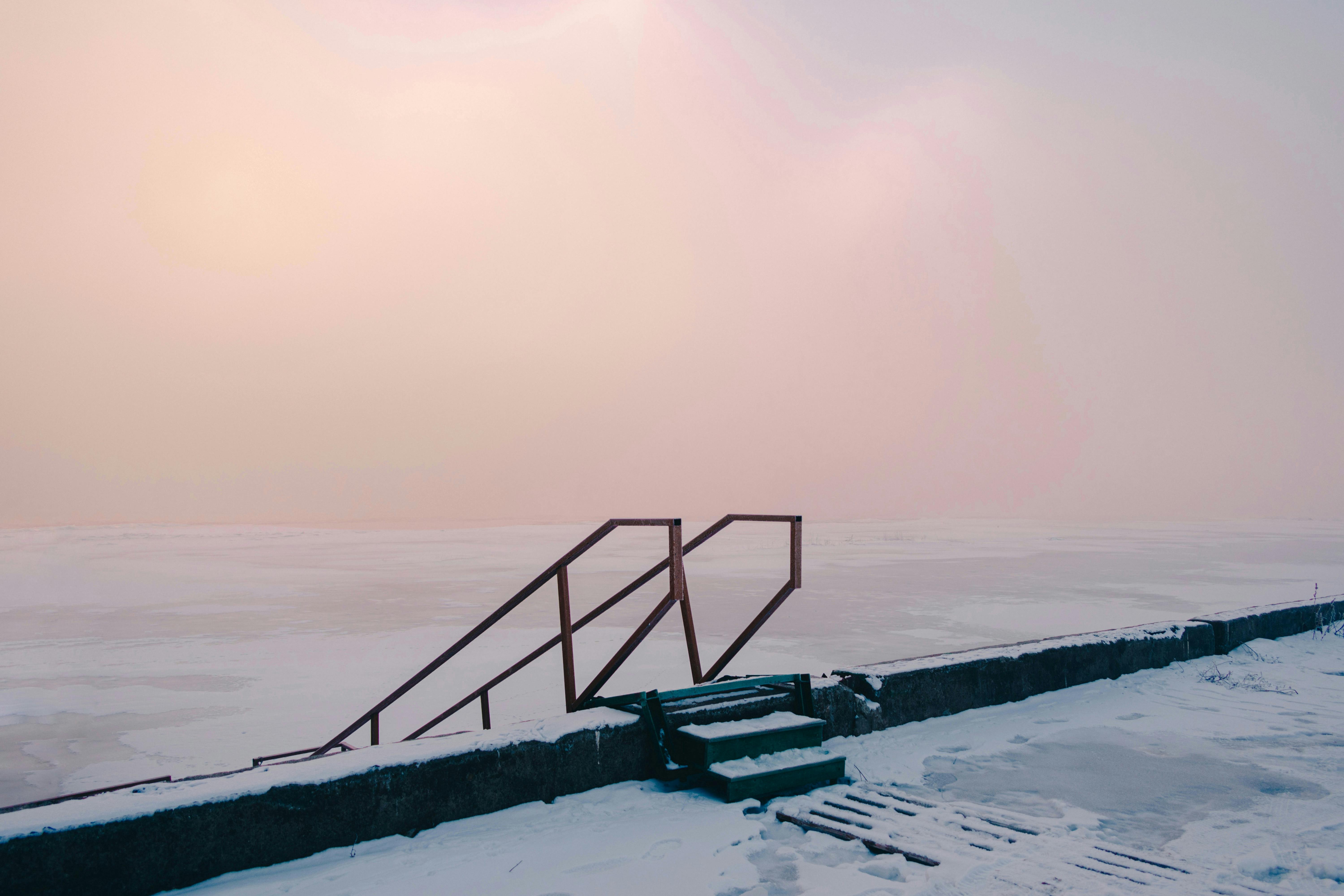 A stairway leading to the water at the edge of a frozen lake