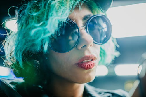A woman with green hair and sunglasses