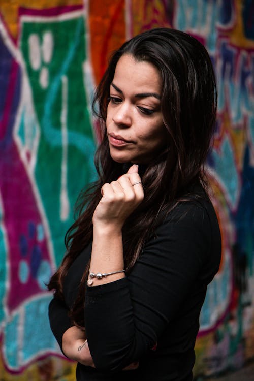 Young Brunette Standing on the Background of a Wall with Graffiti 