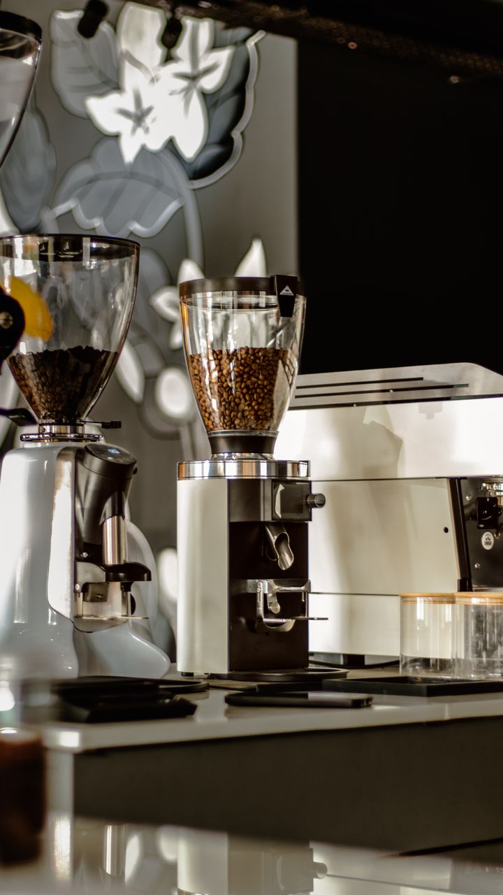 Vintage-style manual coffee grinder placed on a coffee bar hutch middle shelf