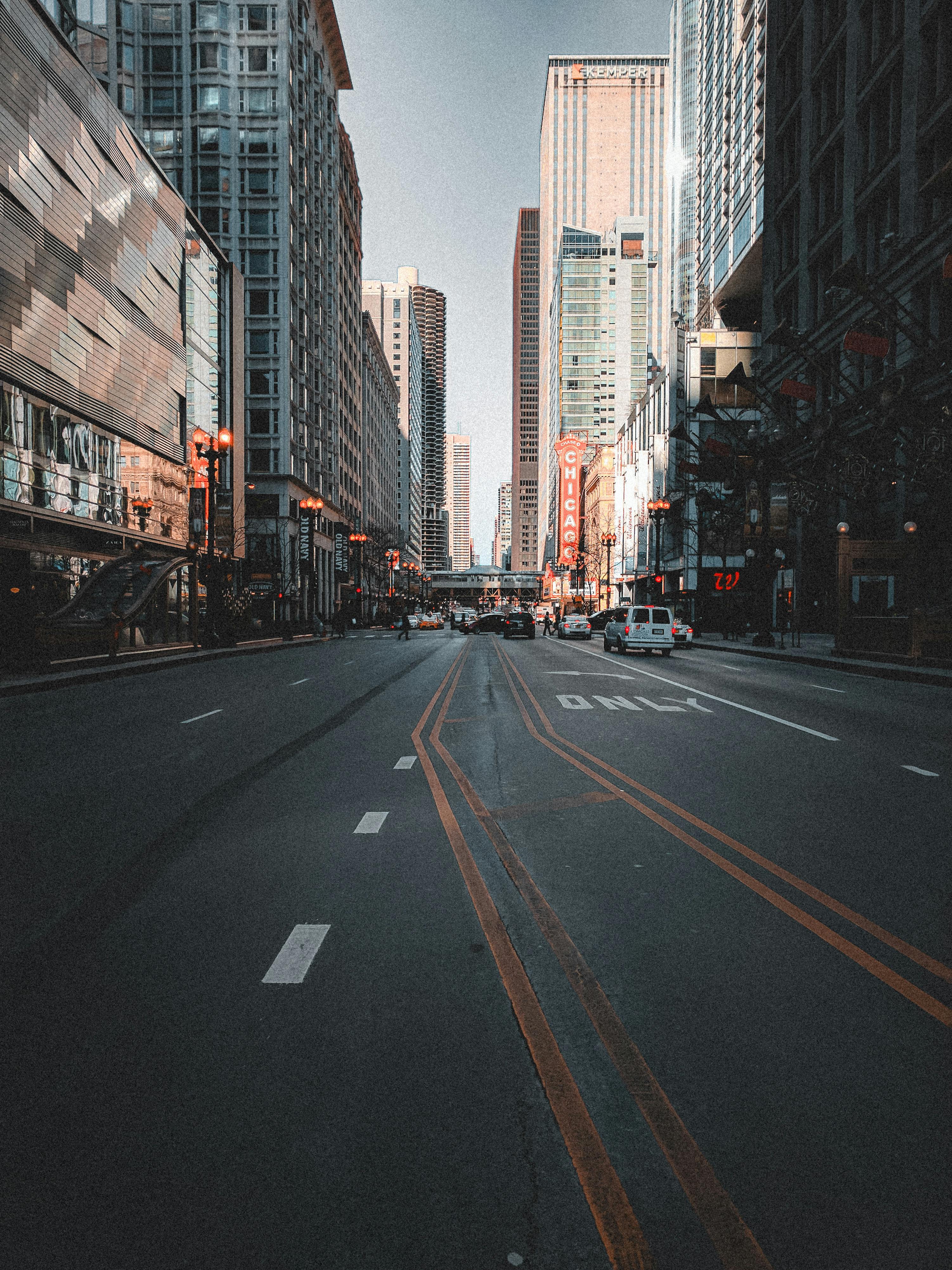 A view of an empty urban street flanked by tall skyscrapers in downtown Chicago.