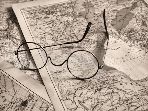Glasses on a map with the words, the world is your oyster