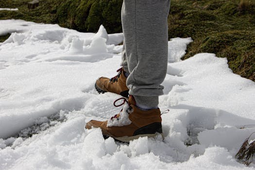 Close-up of hiking boots in snowy Ushuaia, capturing winter exploration vibe.