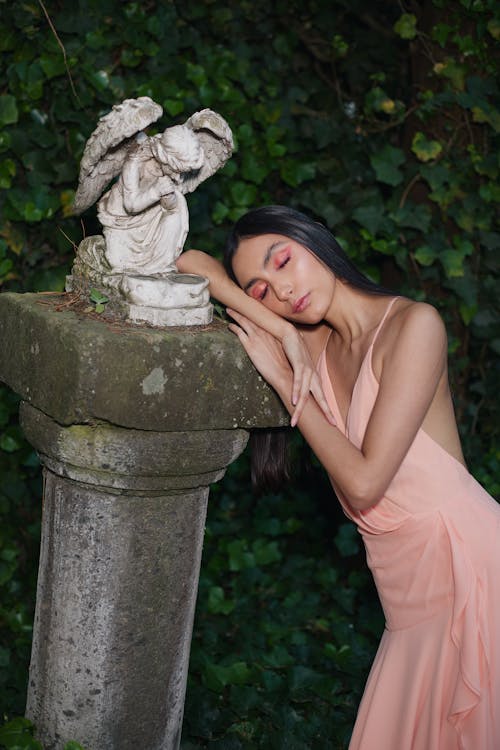 Model in a Pink Dress Leaning on a Sculpture Pedestal