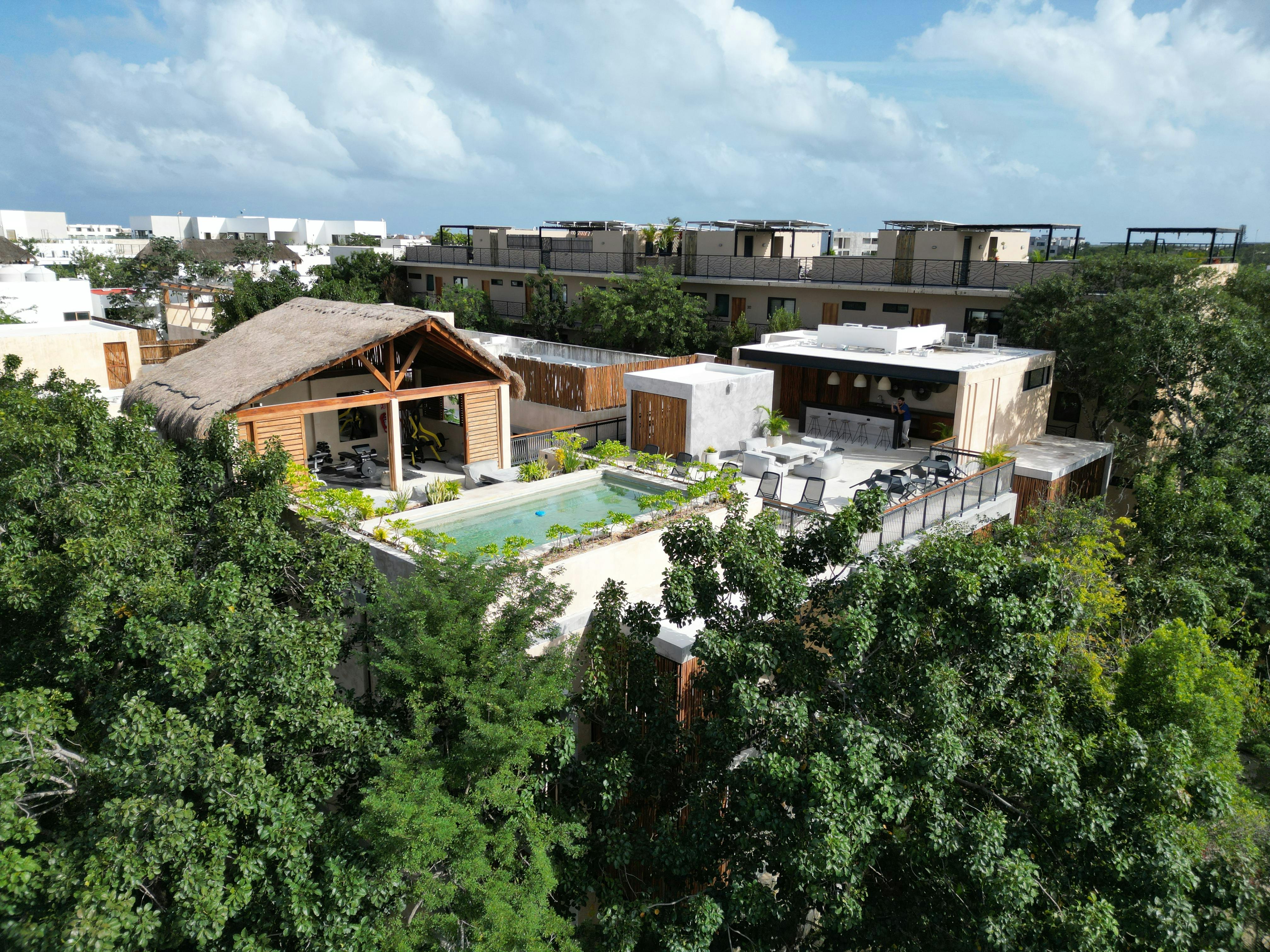 Aerial view of a luxury villa with a private pool nestled in the lush jungle of Tulum, Mexico.