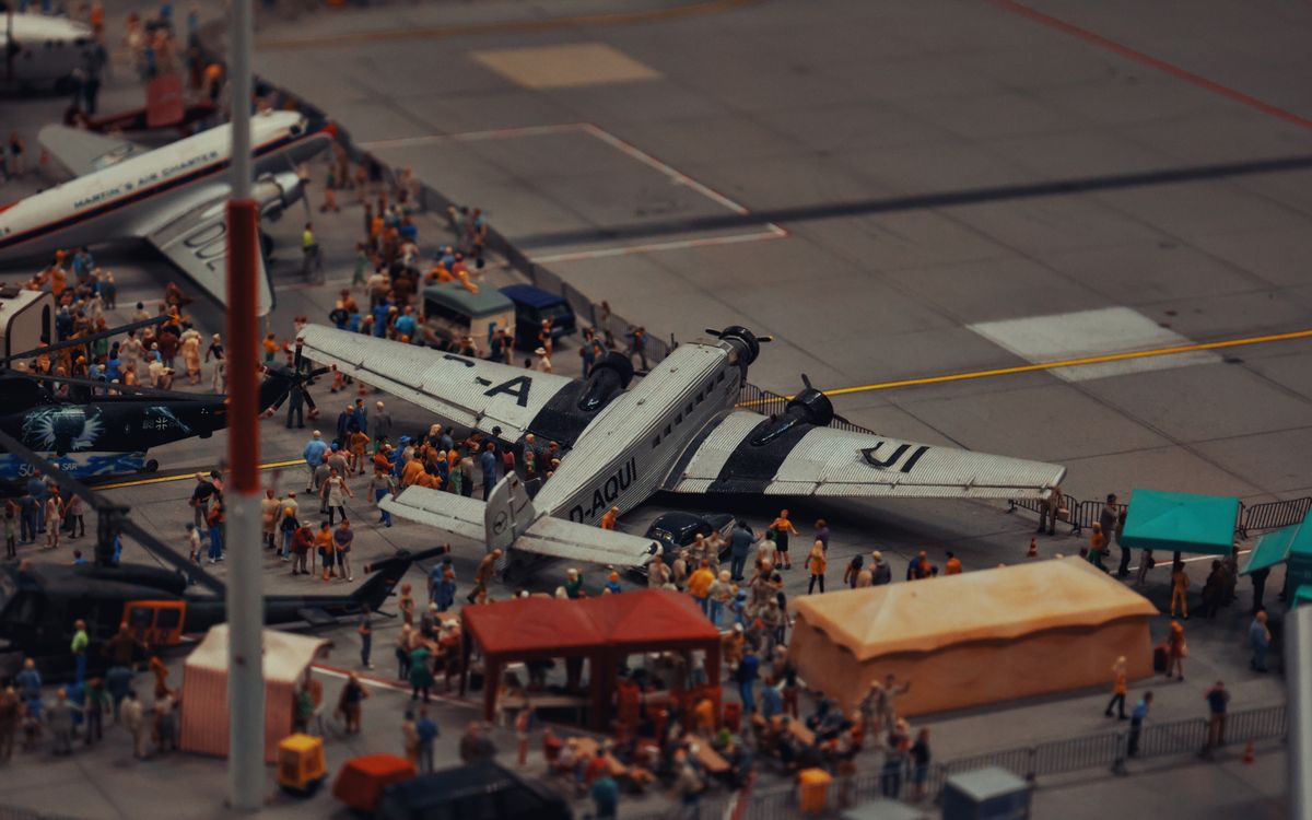 A detailed miniature scene of airplanes and people at a crowded airport display.
