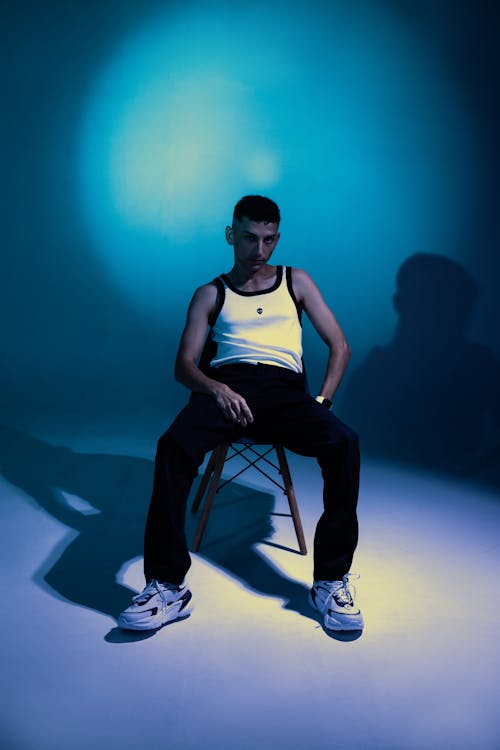 Man in Tank Top Sitting on Chair