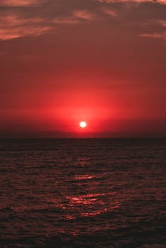 A mesmerizing red sunset casting a warm glow over the ocean in Callao, Lima, Peru.