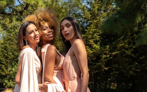 Three Elegant women in Pink Dresses Posing in a Park in Summer