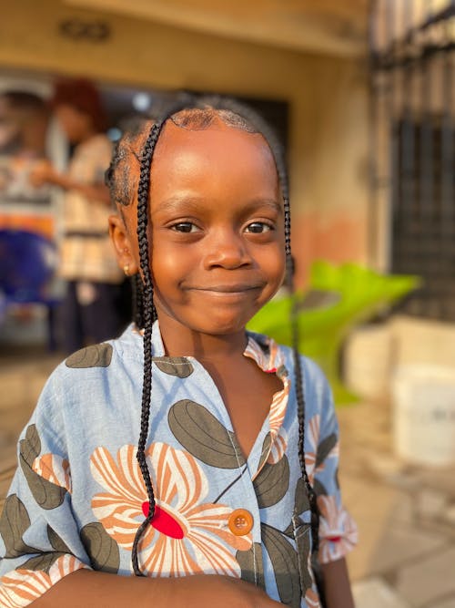 A young girl with braids smiling at the camera