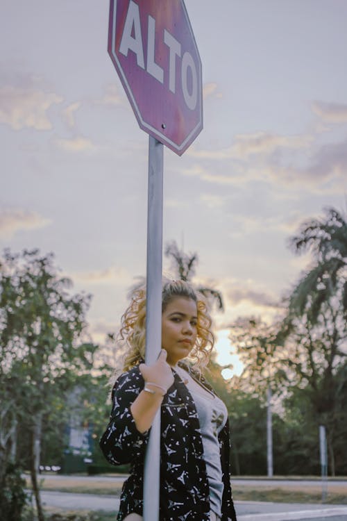 Free Woman Standing Beside Alto Signage Stock Photo