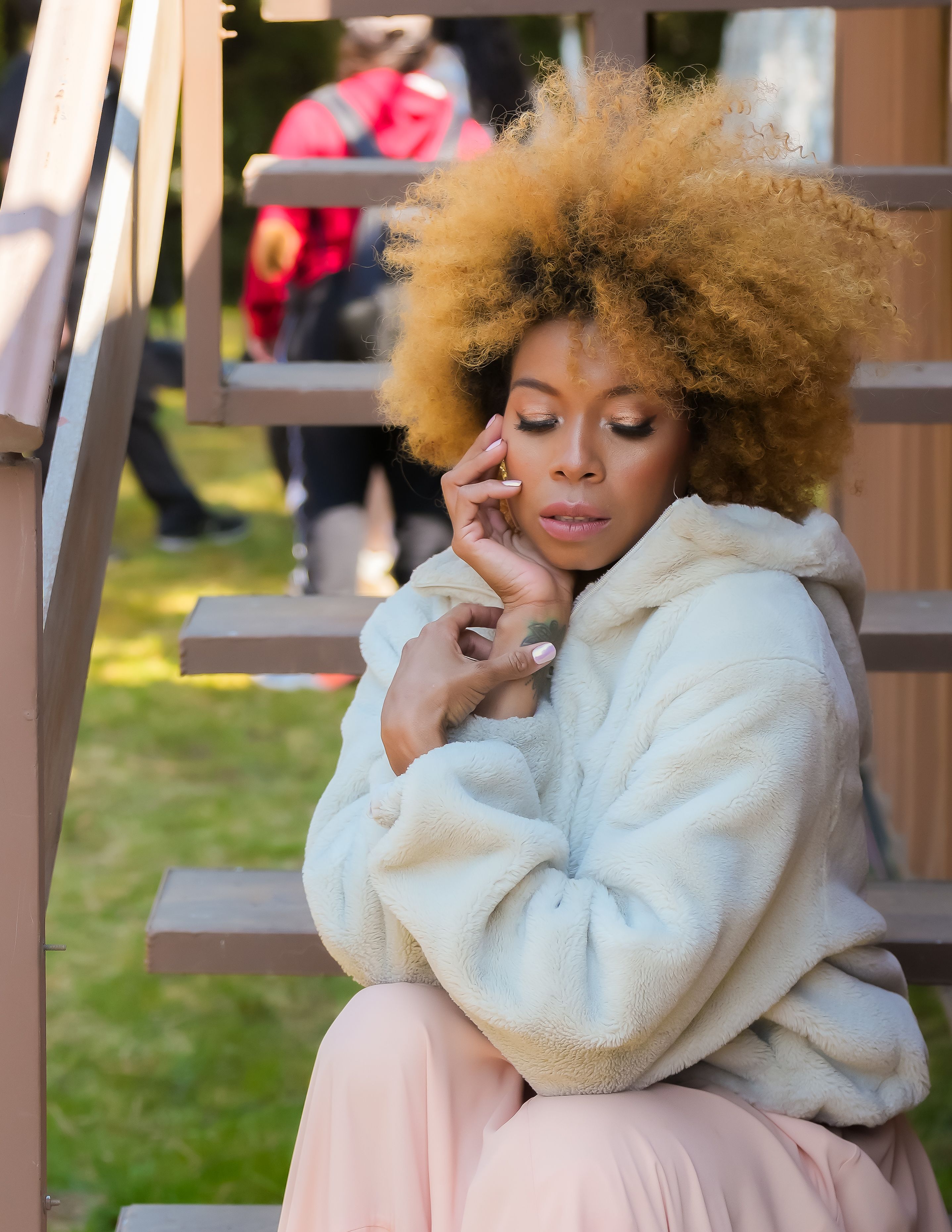 Young Woman in a Pink Dress and a Fuzzy Jacket Sitting on Steps · Free ...