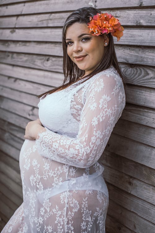 Pregnant Woman Leaning on Brown Wall