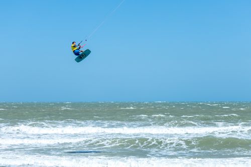 Free A kitesurfer catching air over ocean waves, embodying adventure and excitement. Stock Photo