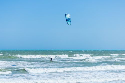 Free A thrilling kitesurfing scene with clear skies and vibrant waves, perfect for summer sports enthusiasts. Stock Photo