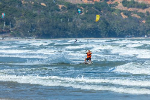 Free A thrilling kitesurfer glides across ocean waves on a sunny day. Perfect adventure scene. Stock Photo