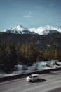 汽车行驶在雪山中，沿途的树木和山峰风景优美