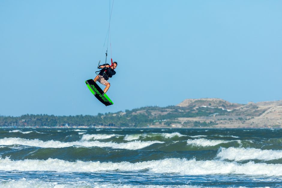 Kitesurfer springt boven de golven in helder weer
