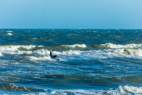 Free A person enjoying an exhilarating kitesurfing experience across the ocean waves. Stock Photo
