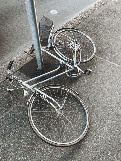Free Broken bicycle lying on a sidewalk in Zurich creates an urban scene. Stock Photo