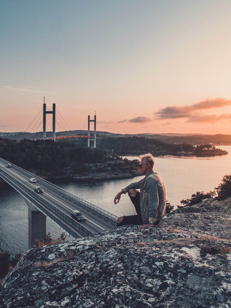 Man Sitting On Rock Formation