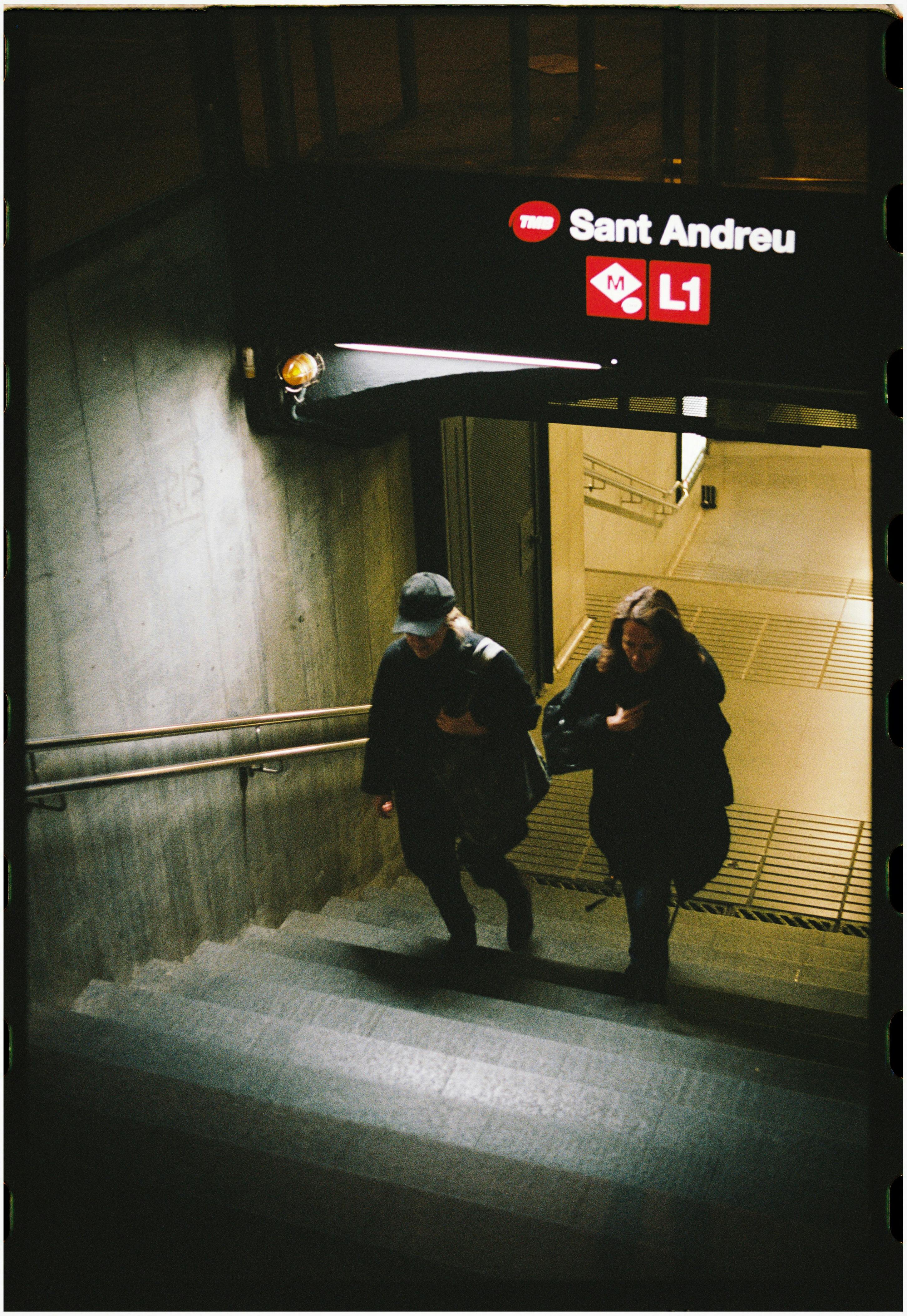 people exiting metro station in barcelona at night