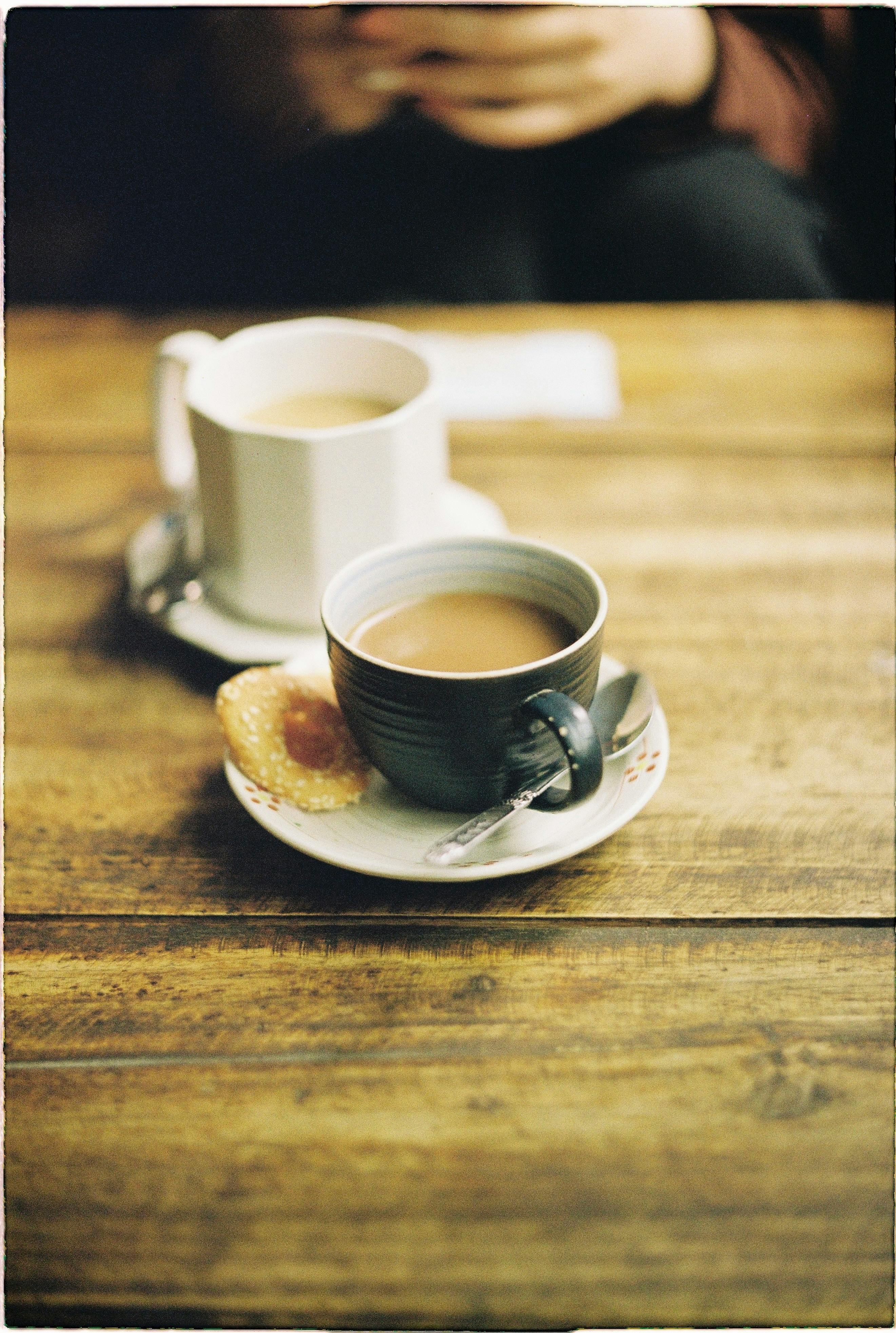 Warm cups of coffee with biscuits on a wooden table, creating a cozy atmosphere in Hanoi, Vietnam.