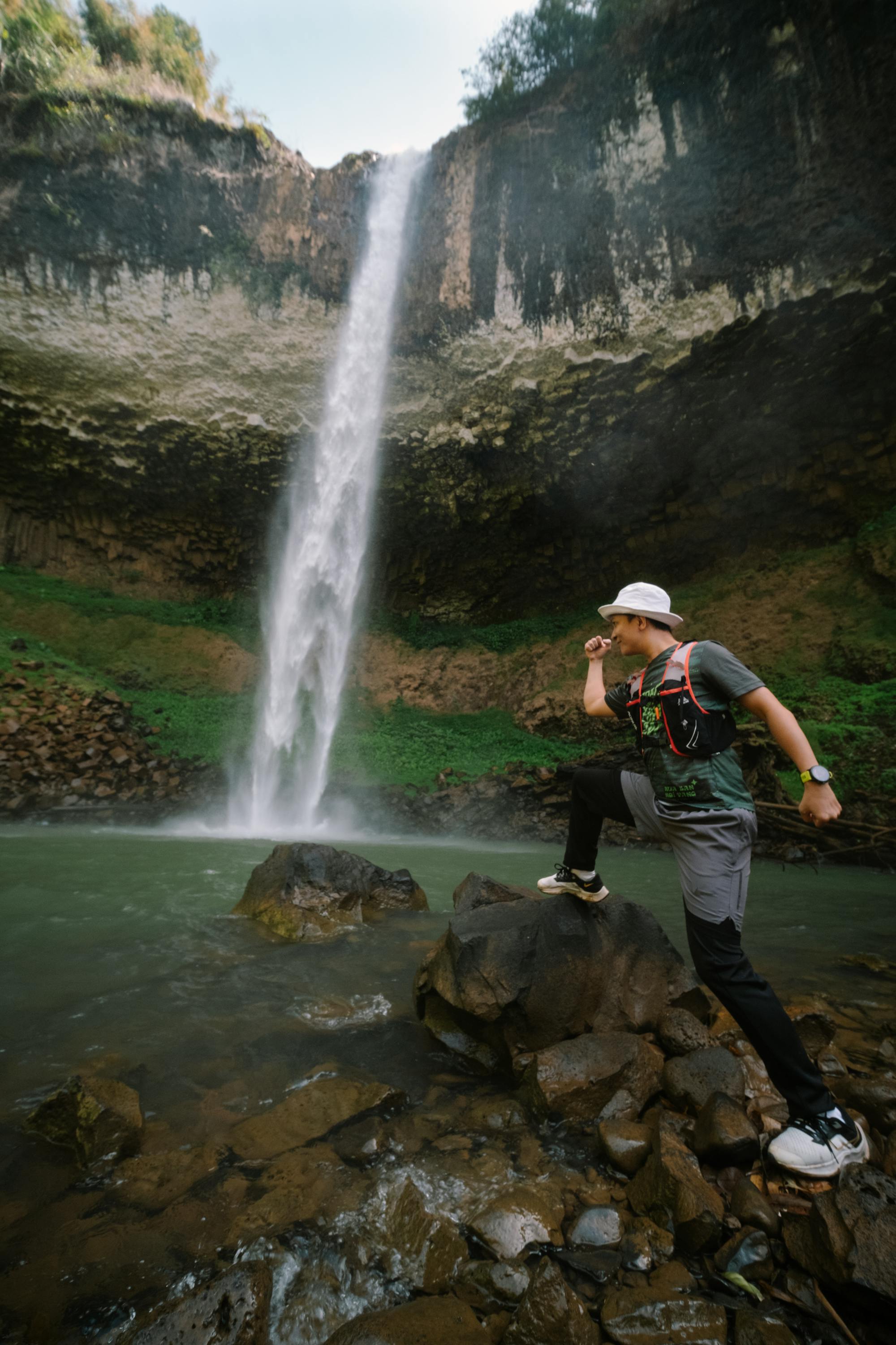 traveler posing under lien nung waterfall