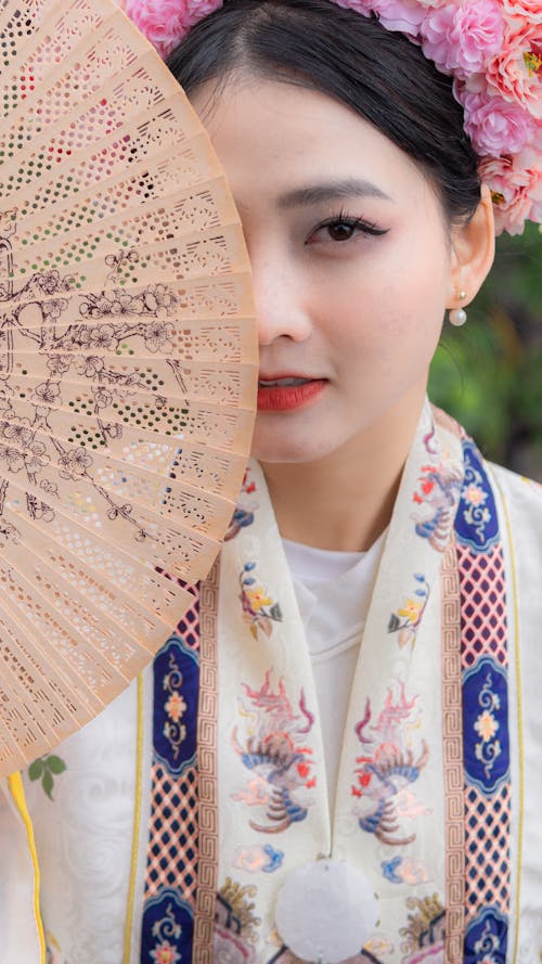 A woman in traditional chinese dress holding a fan