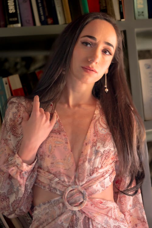 A Woman Standing by a Bookcase