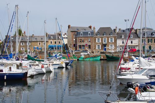 Free Explore the picturesque marina of Paimpol, France, where sailboats are moored by the colorful historic buildings. Perfect summer scene. Stock Photo