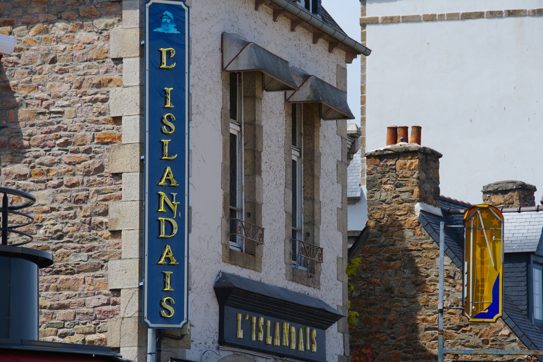 Explore the rustic charm of Paimpol with this stone building featuring stylish signage and old-world architecture.