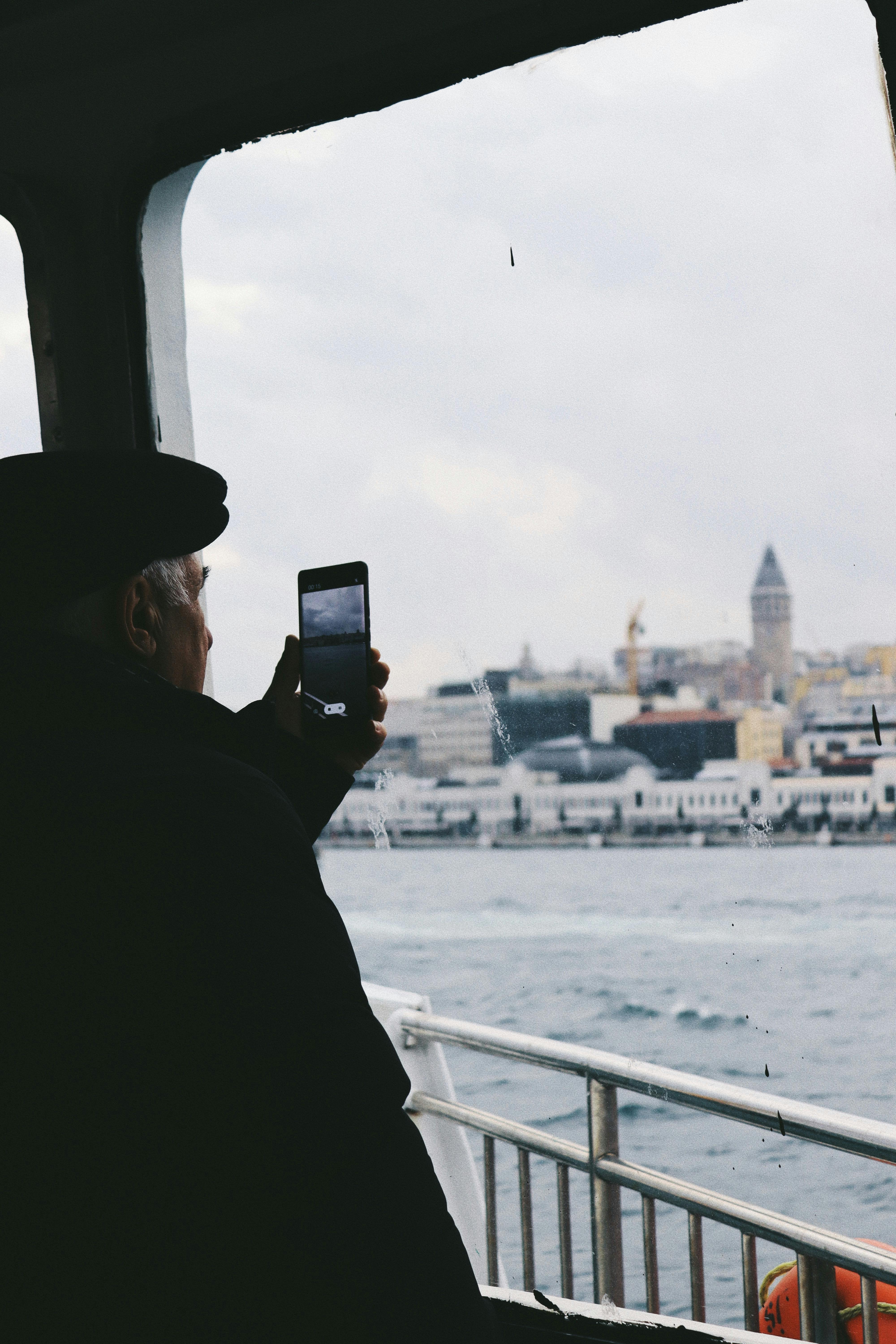 man photographing istanbul from a ferry