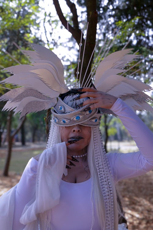 A woman in white with feathers on her head