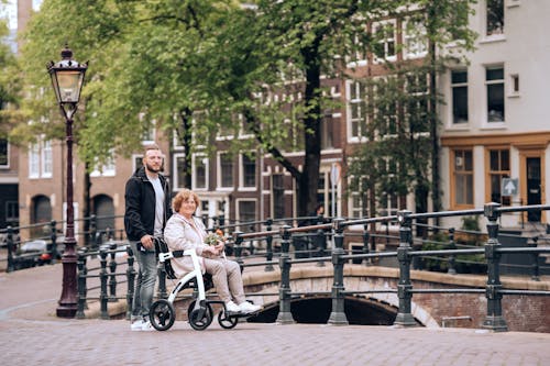 A man and woman walking on a bridge with a baby in a stroller
